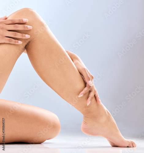 Grooming of a goddess. an unrecognizable womans legs in studio against a blue background.