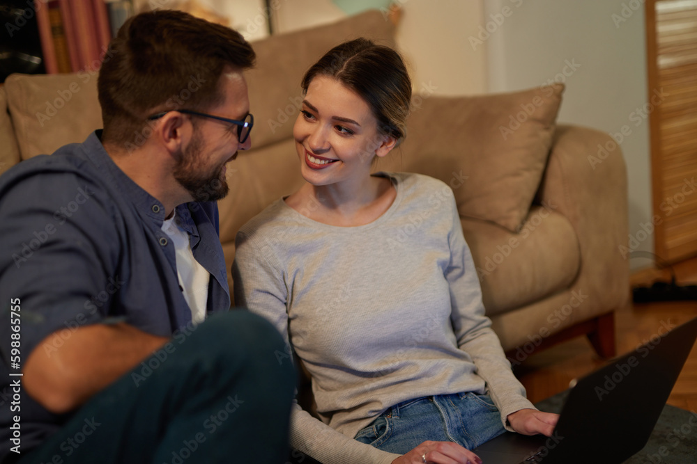 Young couple spending evening at home using laptop Young couple spending evening at home using laptop