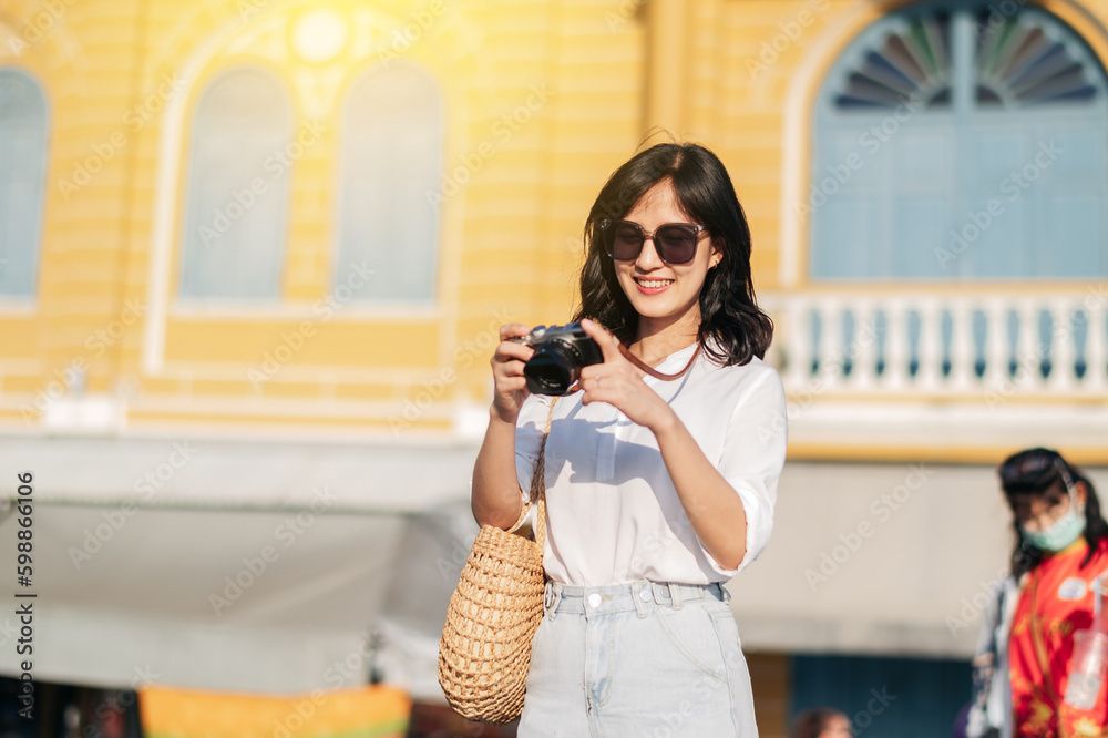 Portrait of asian woman traveler using camera. Asia summer tourism vacation concept