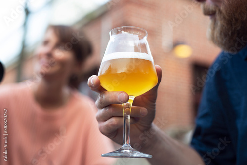 Close-up of man holding glass of beer outdoors photo
