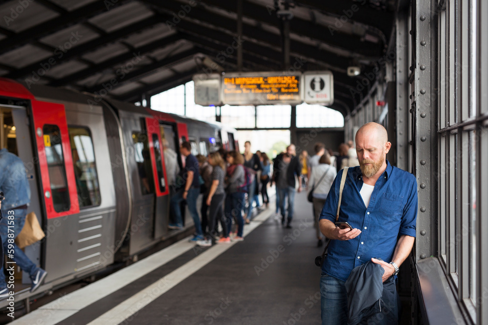 Man with smart phone standing on railway station platform Man with smart phone standing on railway station platform