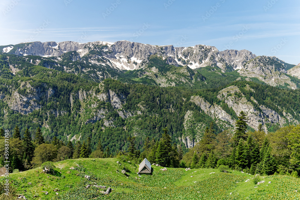 View of different mountain peaks in the spring still with snow. Cottage with a beautiful view. Amazing scenic viewpoint. Hiking lifestyle. Adventurous life. Travel the world.