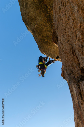Young adult climbing a granite wall at Torrelodones, Madrid. Rock climbing. Extreme sports concept