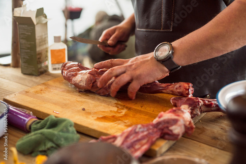 Man preparing raw meat outdoors photo