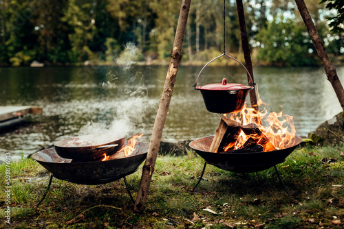 Food cooking in pot and pan over campfires