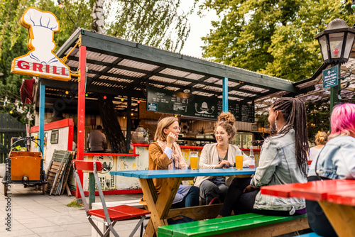 Young female friends relaxing in beer garden