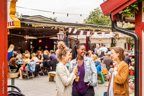 Young female friends relaxing in beer garden