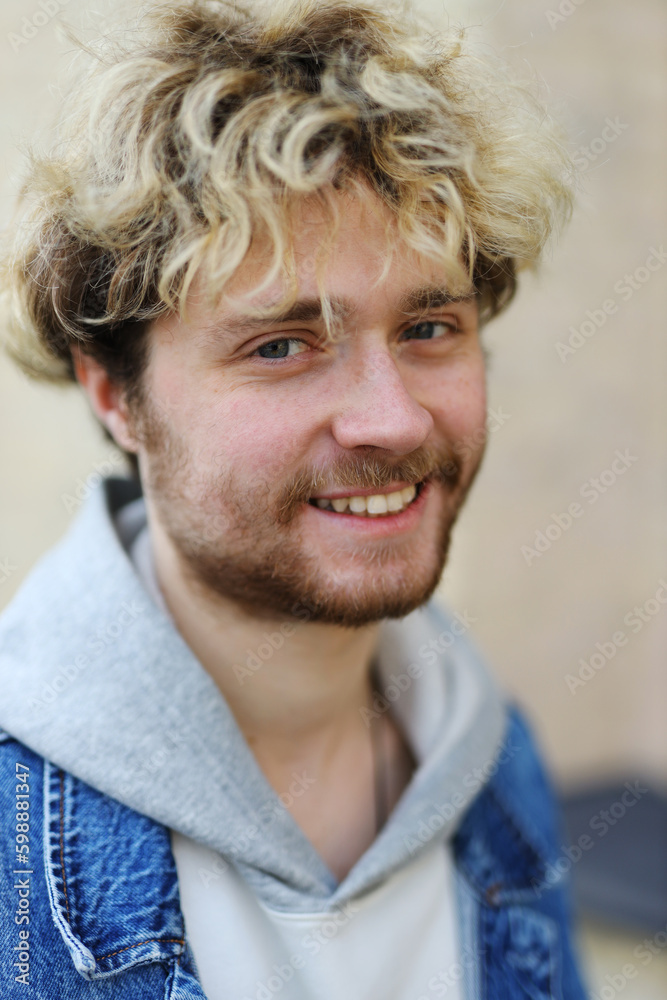 Close-up portrait of smiling attractive young curly blonde man with beard. Close-up portrait of smiling attractive young curly blonde man with beard.