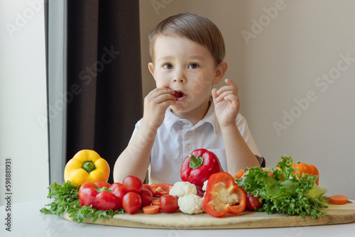healthy food, child eats fresh vegetables, boy with a large dish of vegetables