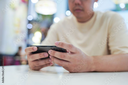 Man playing game on mobile phone. gamer boy playing video games holding Smartphone working mobile devices. cell telephone technology e-commerce concept