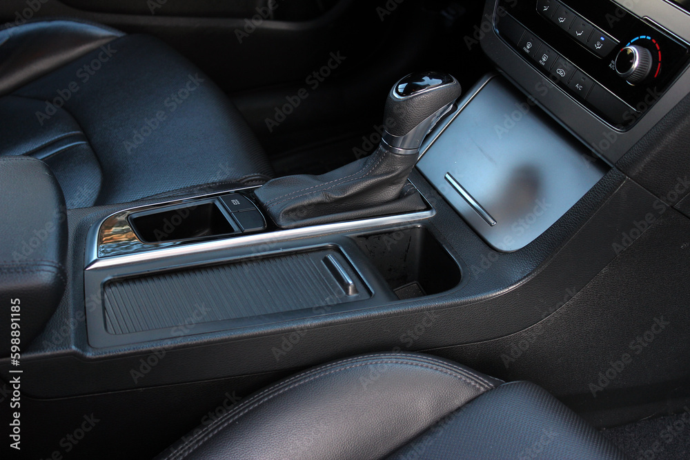 Selector automatic transmission with leather in the interior of a modern car. Close up detail of gear knob. Black leather car interior close up.