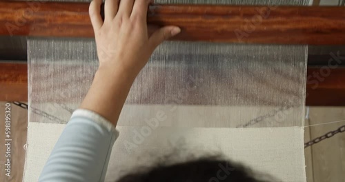 woman weaving cotton fabric on handloom top shot
