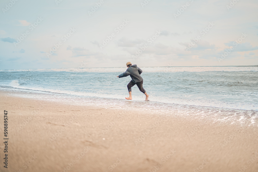 A man playing with the waves on the Samas Beach in Bantul Regency. A man playing with the waves on the Samas Beach in Bantul Regency.