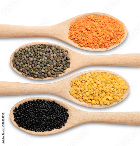 Four varieties of lentils - orange, green, yellow and black on wooden spoons, close-up from a high angle, in front of a white background.
