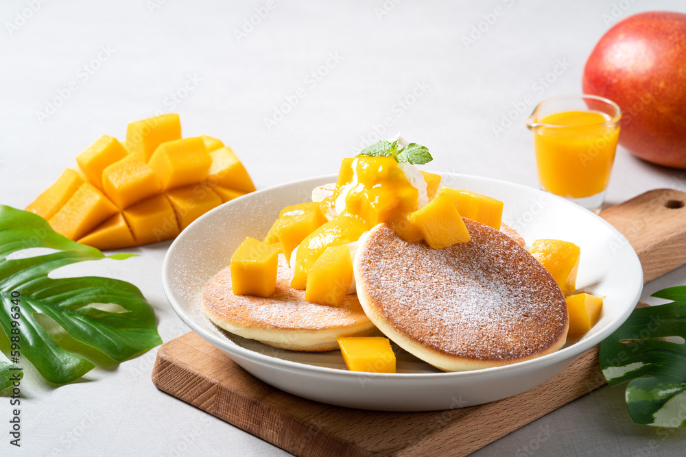 Delicious Japanese souffle pancake with dice mango and jam on gray table background. Delicious Japanese souffle pancake with dice mango and jam on gray table background.
