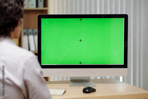 Computer screen with green screen on desk in front of businessman