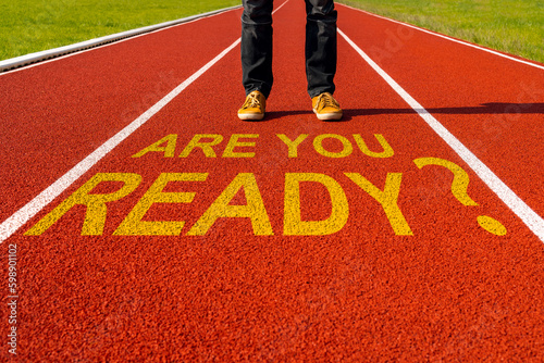 Man stands on the running track with a quote - Are You Ready?