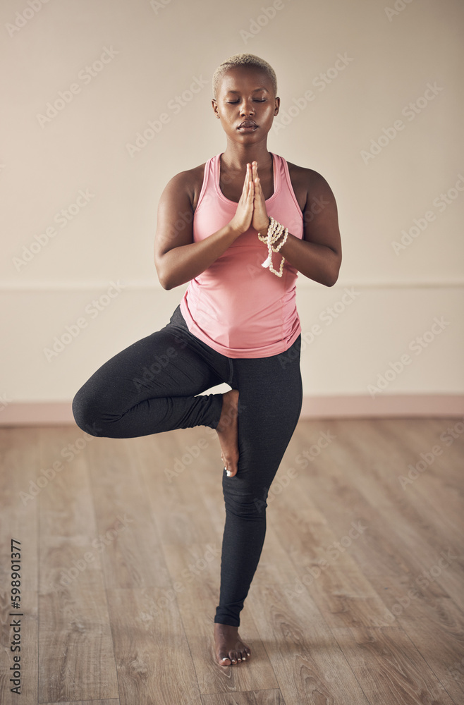 Control your thoughts before they control you. Full length shot of an attractive young woman holding a tree pose while doing yoga alone indoors. Control your thoughts before they control you. Full length shot of an attractive young woman holding a tree pose while doing yoga alone indoors.