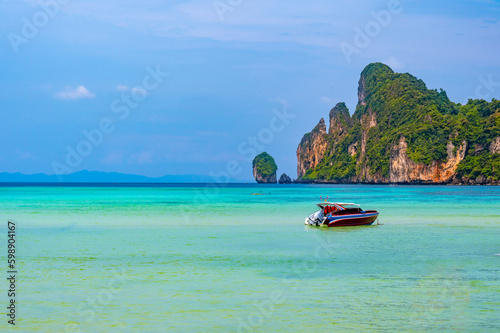 Landscape view of coastline with limestone rock and boats on ocean at Ko Phi Phi islands, Thailand. Concept of exotic tropical vacation and beautiful nature in paradise