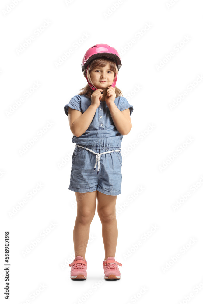 Full length portrait of a girl putting on a pink helmet Full length portrait of a girl putting on a pink helmet