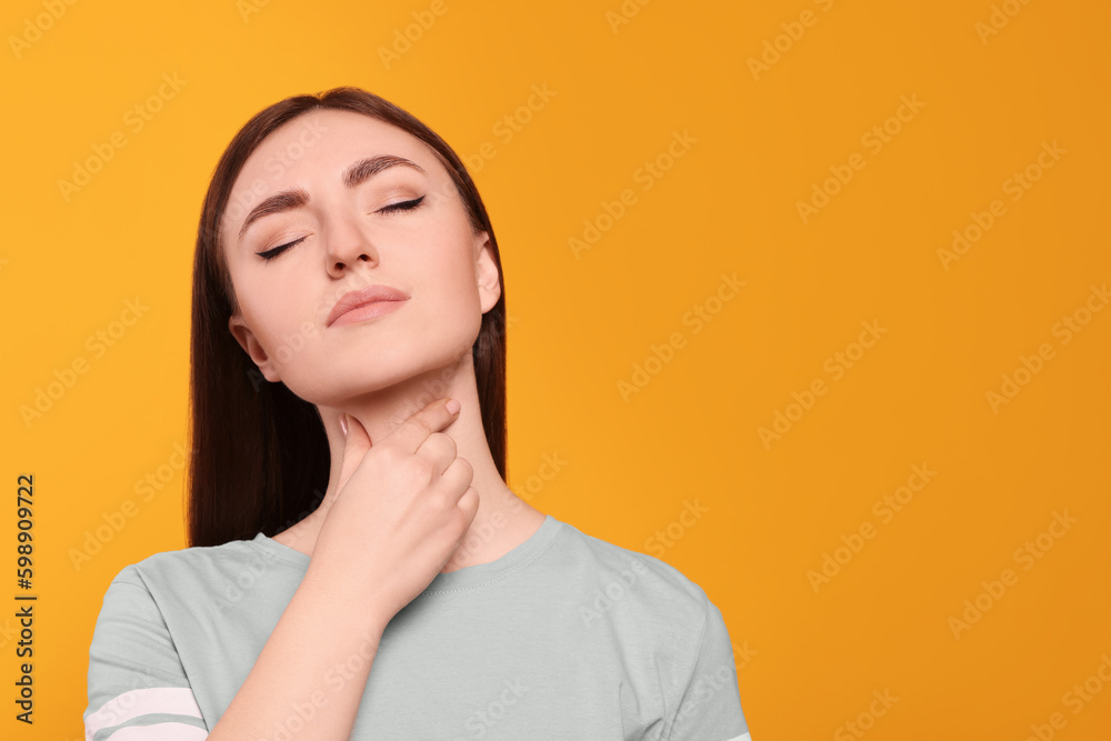 Young woman with sore throat on orange background. Space for text Young woman with sore throat on orange background. Space for text