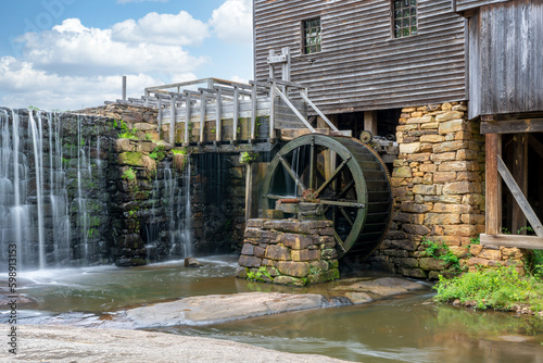 Yates Mill in North Carolina closeup of waterwheel, pond, and building.