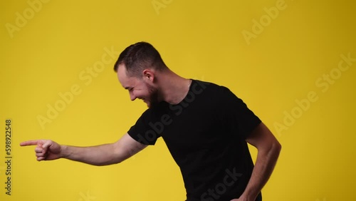 4k video of one man who laughs off someone over yellow background. photo