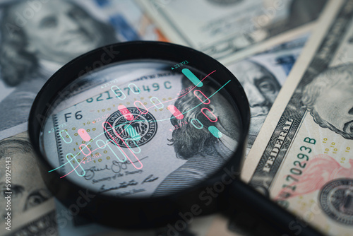 Stock market chart inside magnifier glass on Benjamin Franklin face of USD banknote for focus and analysis currency exchange and global trade forex concept.