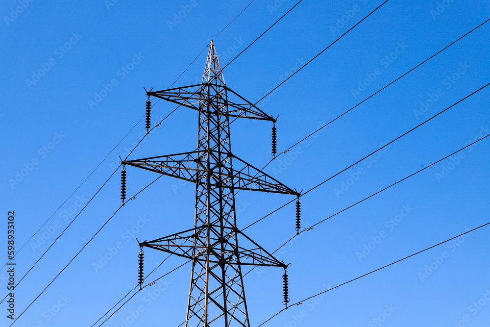 A power line tower with a blue sky in the background A power line tower with a blue sky in the background
