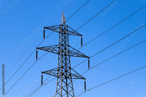 A power line tower with a blue sky in the background