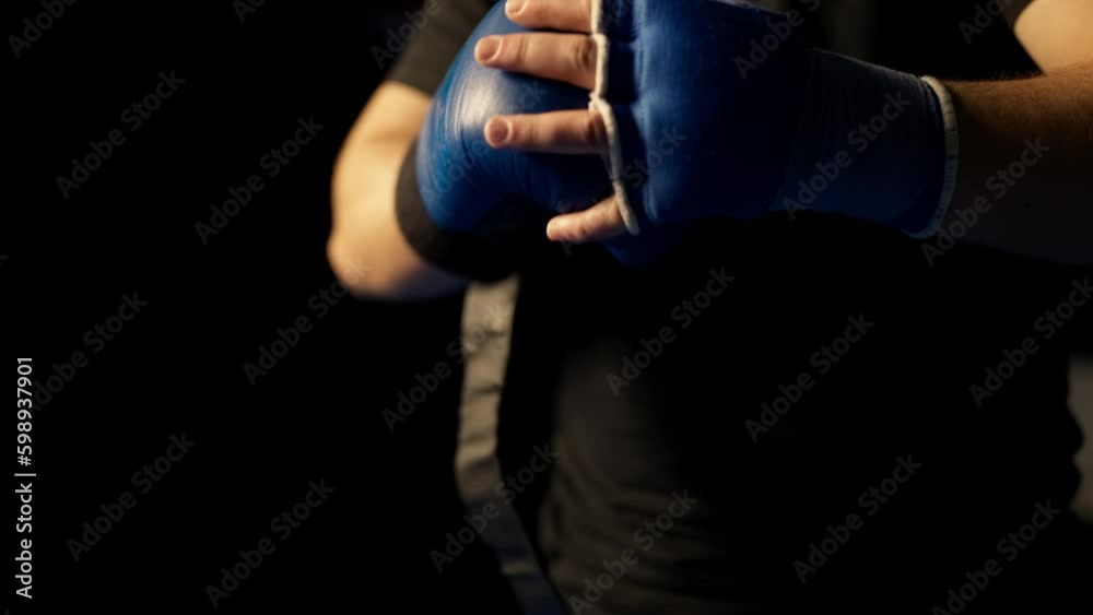 Closeup of man putting boxing gloves on, getting ready for a fight, training Closeup of man putting boxing gloves on, getting ready for a fight, training