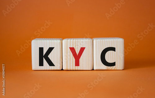 KYC - Know Your Customer. Wooden cubes with word KYC. Beautiful orange background. Business and Know Your Customer concept. Copy space. © Natallia