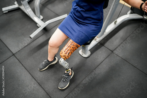 Portrait of disabled athlete woman with prosthetic leg in fitness gym