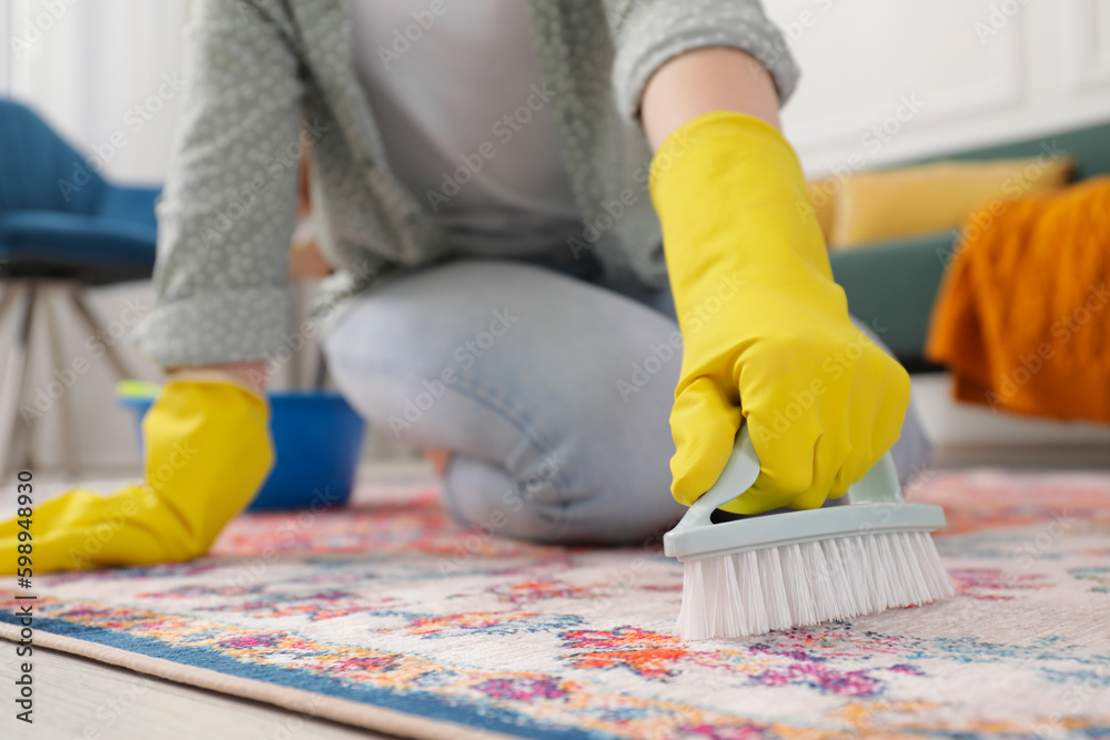 Woman cleaning carpet with brush indoors, closeup. Space for text Woman cleaning carpet with brush indoors, closeup. Space for text