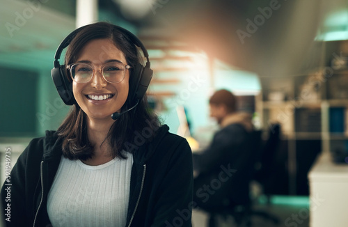 Saving myself no need for the bell. Portrait of a young woman using a headset in a modern office.