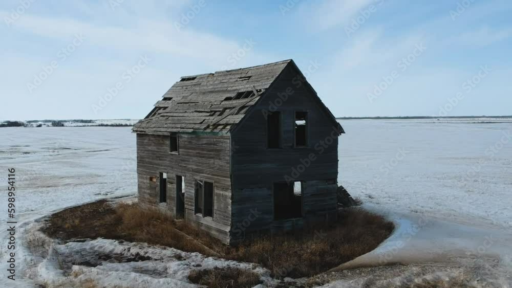 Abandoned Farmhouse on the Prairies in Spring with a Snow Covered Field Abandoned Farmhouse on the Prairies in Spring with a Snow Covered Field