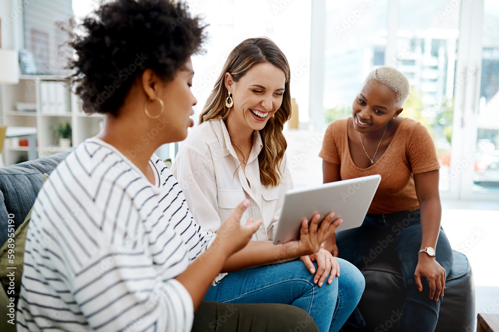 Fototapeta premium This app has become a real game-changer for us. a group of businesswomen working together on a digital tablet in an office.