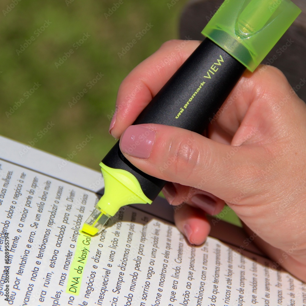 Mulher fazendo marcação de texto em livro Woman marking up text in book Stock Photo Adobe Stock