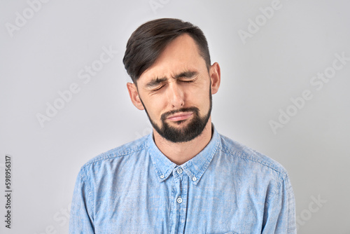 Portrait sad brunette young man isolated on white studio background. Made mistake, upset and depressed.
