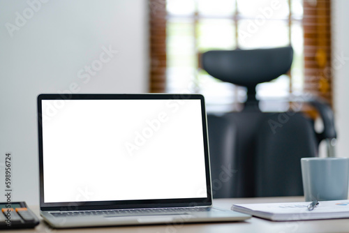 Empty white screen laptop. blank white screen. Mockup image in office. © mojo_cp