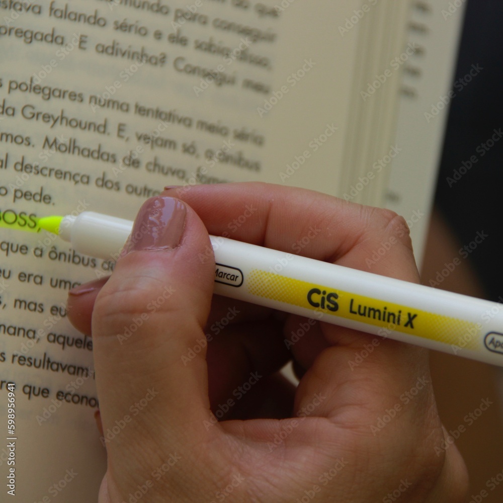 Mulher fazendo marcação de texto em livro Woman marking up text in book Stock Photo Adobe Stock