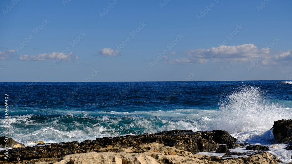 Blue sea wave and white foam and splash. Stone beach on island of Malta, no sandy beach. Summer holiday border frame concept. Tropical island vacation backdrop. Tourist travel banner design template. Blue sea wave and white foam and splash. Stone beach on island of Malta, no sandy beach. Summer holiday border frame concept. Tropical island vacation backdrop. Tourist travel banner design template.