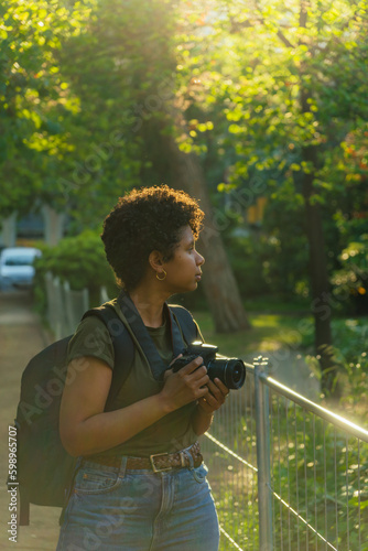Photos Young black African American female photojournalist with dark curly hair looking