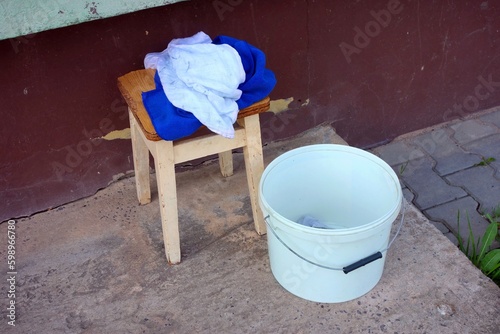 Bucket and cloths on a chair for cleaning outside