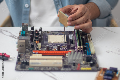 Technician preparing to assemble CPU into motherboard