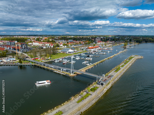 Marina in Gizycko, Poland, Niegocin lake - drone aerial photo of sailboats and bridges, blue cloudy sky, city in the background © Łukasz Tyczkowski