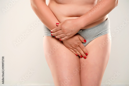 Woman covering her private parts close up, isolated.