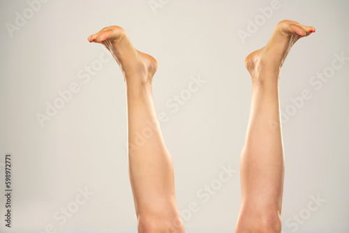 Female legs lifted up in the air, isolated on white.
