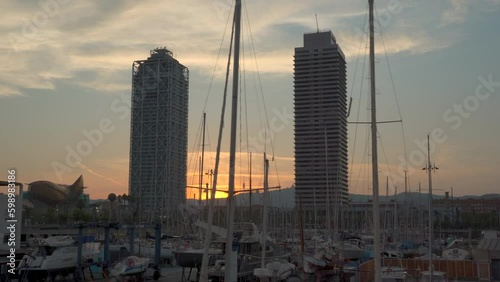 Traveling or tracking shot panorama view of Vila olimpica in Barcelona Towers in sunset Torre Mapfre Hotel Ars and the Olimpic Harbour photo