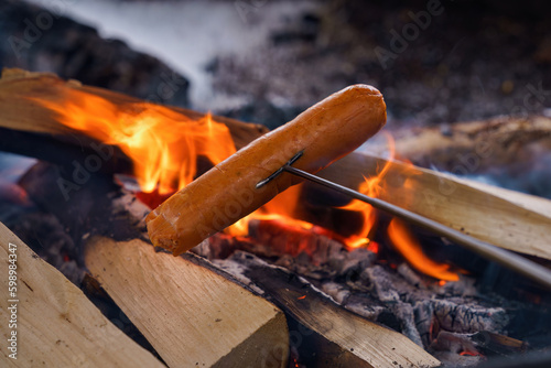 Grilling sausage over a campfire in winter, Repovesi National Park ,Finland. photo